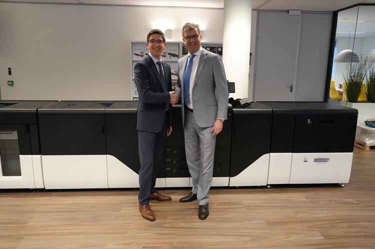 Professional handshake in a modern workspace showcasing collaboration and advanced office technology.